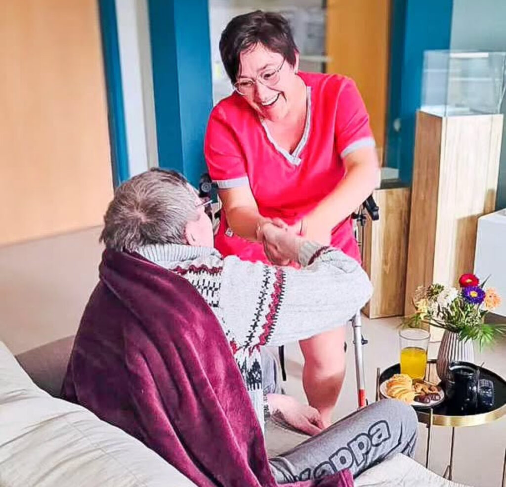 Pflegefachkraft lächelt Patienten an